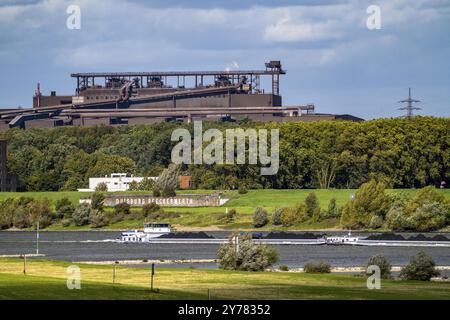 Rhine at Duisburg-Beeckerwerth, freighter loaded with coal, Oxygen steelworks 2 Industrial backdrop of the ThyssenKrupp Steel steelworks in Bruckhause Stock Photo