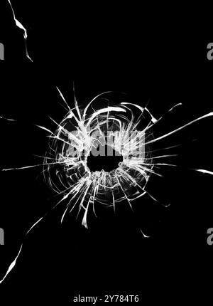 The effect of cracks and bullet holes on the glass. Broken car glass. Shot of a weapon in the windshield Stock Photo