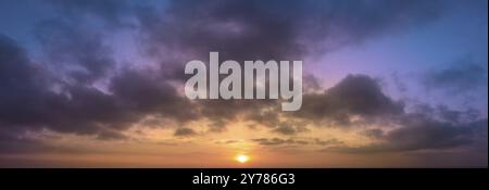 Panoramic abstraction of sunrise with dramatic blurred background of clouds and blue sky Stock Photo