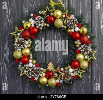 Christmas wreath with Christmas balls and toys hanging on a wooden wall Stock Photo