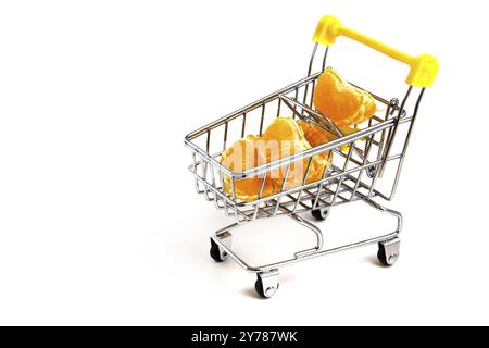 Particles of peeled tangerine in a shopping cart isolated on white background Stock Photo