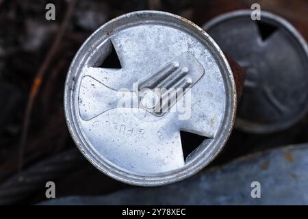 old 1962 zip top pull tab beer can top with the words lift tab and pull that has been opened with a church key can opener Stock Photo