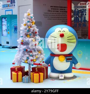 Doraemon standing next to the Christmas tree Stock Photo