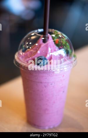 Mixed berry smoothie on the wooden table with blurred image bokeh of the restaurant Stock Photo