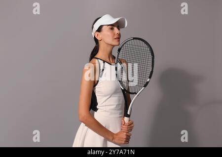 Tennis player with racket on grey background Stock Photo