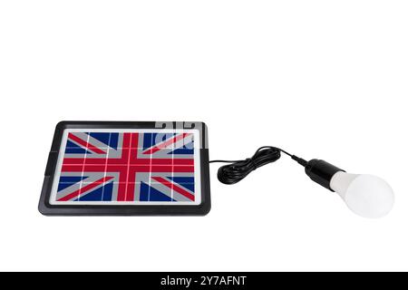 Solar panel in shape of UK flag connected to a light bulb on white background. Concept for development of renewable green alternative energy in UK Stock Photo