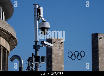 29 September 2024, Berlin: Video cameras are installed next to the stadium entrance at Coubertinplatz (south gate). The Olympic rings can be seen in the background above the entrance on Olympic Square. Photo: Soeren Stache/dpa Stock Photo
