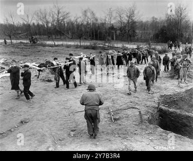 German civilians from the town of Nordhausen carry the bodies of prisoners from the Nordhausen concentration camp to mass graves. Actions like this were part of the Denazification process. This process was an attempt to rid Germany and Austria culture and society of nazi influence and ideology. A part of the process included confronting the public with the evidence of the crimes that were carried out in their area. Stock Photo