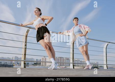 Two Caucasian women doing sport together and enjoying good weather and fresh air on waterfront Stock Photo