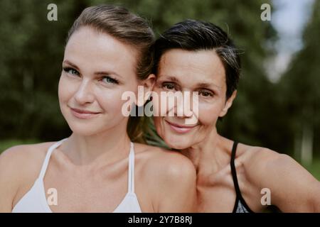 Medium close up portrait of smiling adorable mother and daughter looking directly at camera Stock Photo