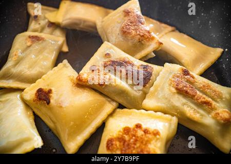 Bavaria, Germany - September 29, 2024: Fried Bavarian Maultaschen in a pan with golden brown spots and light steam *** Gebratene bayerische Maultaschen in einer Pfanne mit goldbraunen Stellen und leichtem Dampf Stock Photo