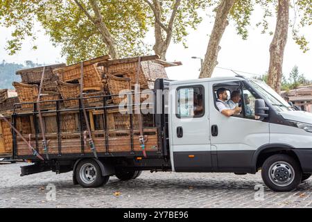 Wicker basket runners on the Portuguese Island of Madeira unloading their baskets off a wagon in preparation for the days toboggan rides for tourists Stock Photo