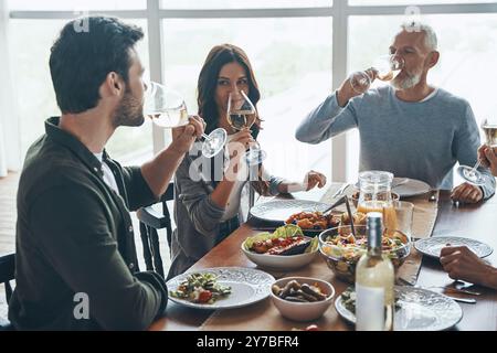 Happy multi-generation family drinking wine while having dinner together Stock Photo
