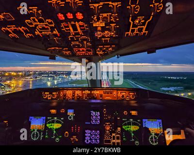 Airplane cockpit view during night landing approach with runway lights. High quality photo Stock Photo