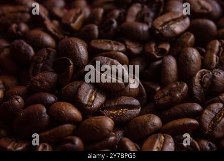 Brown Roasted Coffee Beans Closeup On blurred Background of coffee beans. Top view of backdrop of dark brown coffee beans. Coffee Beans texture. Stock Photo