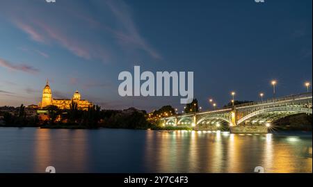 Night view of Salamanca (Spain) with the cathedral and the Enrique Estevan bridge from the viewpoint of the pier on the Tormes river Stock Photo