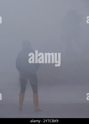 Teignmouth, Devon, UK. 29th Sep, 2024. UK weather: Wind, rain and gigantic waves crash into Teignmouth, Devon. Pictured: Figure drenched in sea spray as waves hit the Teignmouth sea wall. Credit: nidpor/Alamy Live News Stock Photo