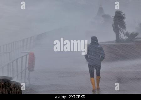 Teignmouth, Devon, UK. 29th Sep, 2024. UK weather: Wind, rain and gigantic waves crash into Teignmouth, Devon. Pictured: Figure drenched in sea spray as waves hit the Teignmouth sea wall. Credit: nidpor/Alamy Live News Stock Photo