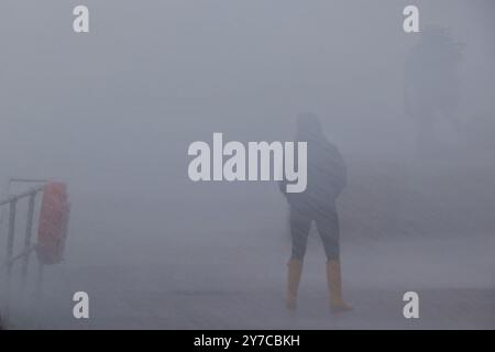 Teignmouth, Devon, UK. 29th Sep, 2024. UK weather: Wind, rain and gigantic waves crash into Teignmouth, Devon. Pictured: Figure drenched in sea spray as waves hit the Teignmouth sea wall. Credit: nidpor/Alamy Live News Stock Photo