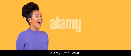 Excited woman with curly hair against a bright orange background Stock Photo