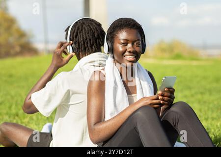 Young adults enjoying music together in a park on a sunny day Stock Photo