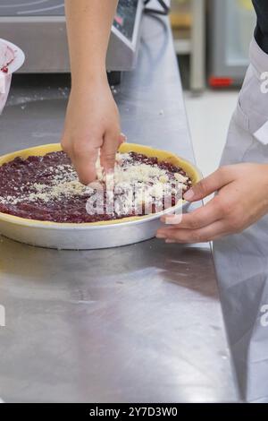 Close-up of a person sprinkling a cake tin with sprinkles Stock Photo
