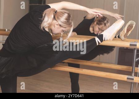 Ballerina in black wear is practicing in the dance studio. woman in tutu and pointe shoes in a dance class Stock Photo