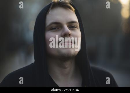 Portrait of beautiful young man wearing hood, nature park Teenager being thoughtful and contemplative, recreation lifestyle Stock Photo