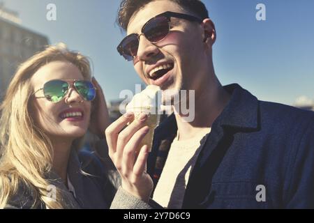 Happy romantic caucasian couple in sunglasses. Funny girl eat the ice cream Stock Photo