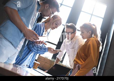 Group of colleagues having meeting in boardroom while working on big presentation and preparing their business strategy. Creative designers looking br Stock Photo