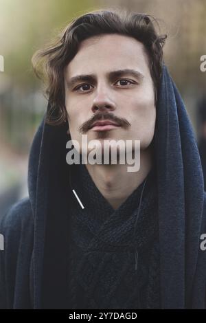Handsome young curly man aims at his sight far away. He is taking important decesion Stock Photo