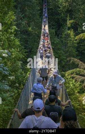 Capilano Suspension Bridge, people crossing a suspension bridge in a dense forest, surrounded by lush green nature, Vancouver, British Columbia, Canad Stock Photo