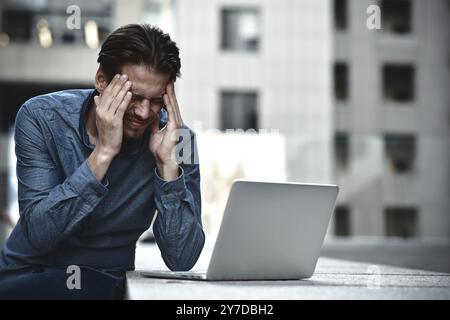 Stressed businessman after project failure. Confused young man frustrated by online problem Stock Photo