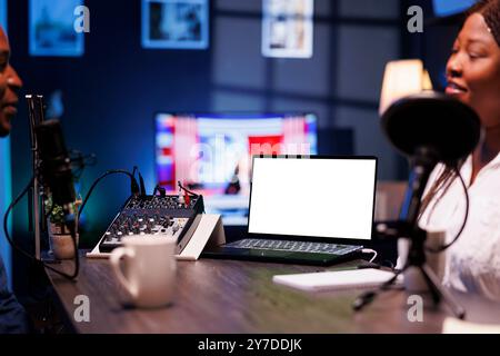 Detailed view of laptop featuring blank chromakey screen for talk show promotion. Selective focus on portable computer displaying an isolated white screen for advertising an online streaming platform. Stock Photo