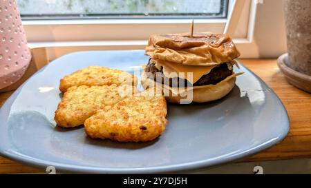 Home made cheeseburger with hash browns on blue plate, delicious food, tasty dinner Stock Photo