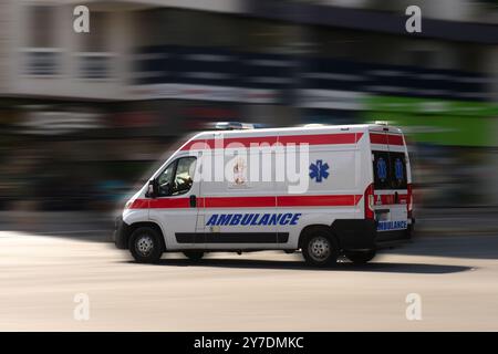 Speedy ambulance racing against time, with a dynamic, blurred city background. Stock Photo