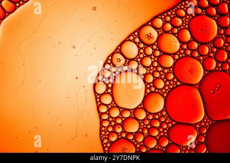 Textured river of vegetable oil in a close up with bubbles in an abstract of red Stock Photo