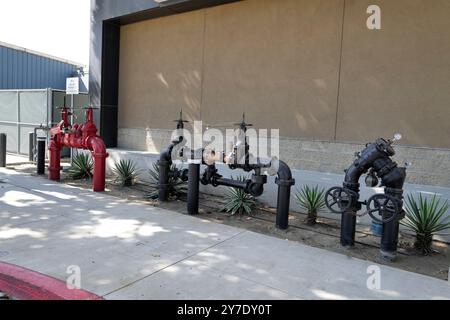 A detailed look at various backflow prevention valves and fire safety systems installed around an industrial site. Stock Photo