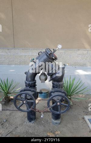 A detailed look at various backflow prevention valves and fire safety systems installed around an industrial site. Stock Photo