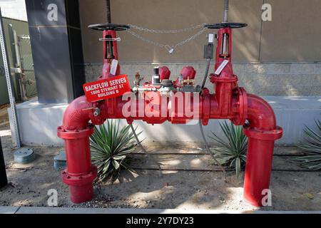 A detailed look at various backflow prevention valves and fire safety systems installed around an industrial site. Stock Photo