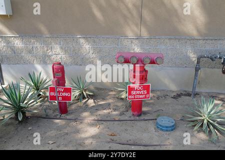 A detailed look at various backflow prevention valves and fire safety systems installed around an industrial site. Stock Photo