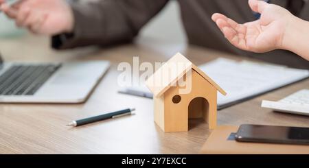 Real Estate Negotiation Over Property Contract and House Model Stock Photo