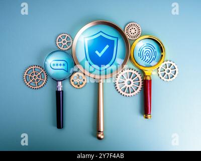 Shield padlock, two step authentication password and fingerprint icons in magnifying glasses near gears and cogwheels, blue background. Cyber security Stock Photo
