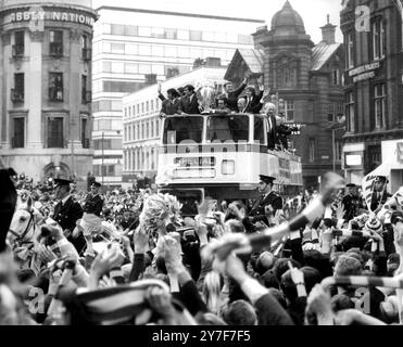 The Manchester United team and manager Matt Busby, along with the European Cup ride in triumph through Albert Square as thousands of delirious fans celebrate on their return to their home city after defeating Benfica 4-1 at Wembley. Stock Photo