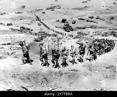 US Troops move up Omaha beach in Normandy. They are part of the ever increasing reinforcements arriving in France to support the forces which made the initial landings on the beach head. 6th June 1944 Stock Photo