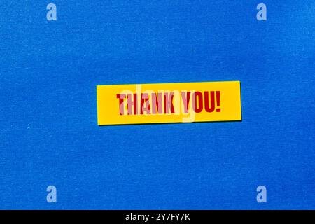 Thank you message written on yellow sticker with blue background. Conceptual thank you symbol. Copy space. Stock Photo