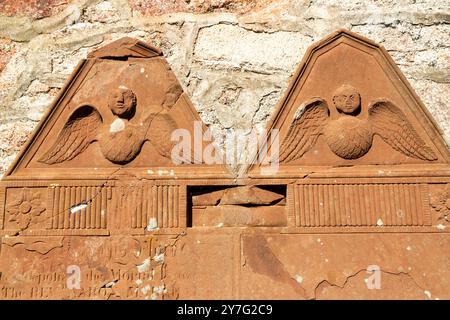 Detail of head with Angel wings carved onto a headstone in St Catherine's Church, Boot, Cumbria, England Stock Photo