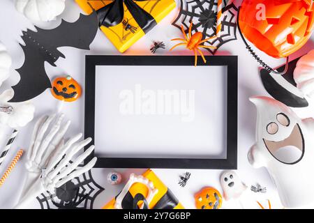 Happy Halloween holiday greeting card background. Flat lay gift boxes, set of Halloween symbols- spiders, bats, pumpkin, party decorations on white ba Stock Photo