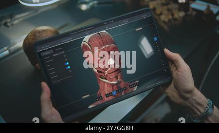 Advanced archaeological lab: Archaeologist scans fossil skull through camera using tablet computer, studies ancient human anatomy. Screen shows user interface of 3D modeling software. AI technology. Stock Photo