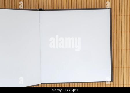 close up of  blank square page of opened sketch book lying on bamboo mat Stock Photo
